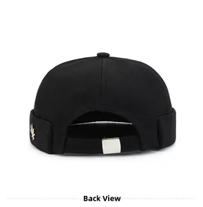 Detail view of black cotton docker hat featuring back metal strap and gold bird emblem