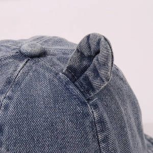Dettaglio cappello pescatore in denim blu scuro con orecchie e trama a saia