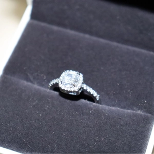 Elegant square cushion cut zircon ring in silver finish with pavé setting on jewelry box