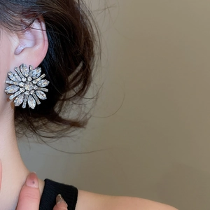 Close-up of luxury sunflower crystal stud earrings with marquise-cut rhinestones