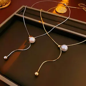 Minimalist pearl necklace with snake chain in gold and silver finish on luxury tray