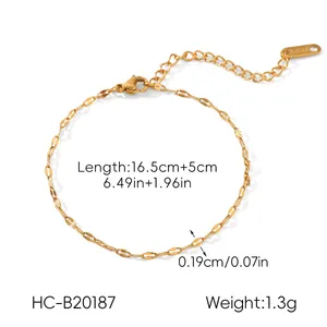 Détail du bracelet en acier inoxydable doré avec fermoir mousqueton et étiquette logo
