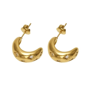Close-up of golden crescent earrings with zircon star settings on white background