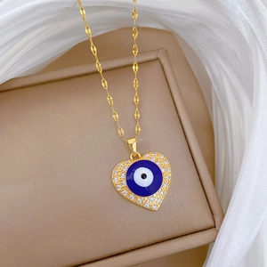 Detail of gold heart pendant with evil eye and sparkling pavé cubic zirconia