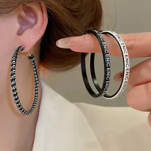 Boucles d'oreilles créoles géométriques avec lettres en cuir et texture tissée