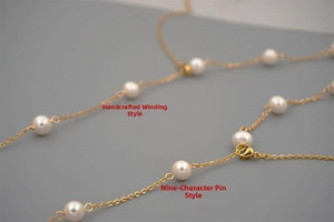 Detail view of handcrafted gold chain links and white freshwater pearls connection