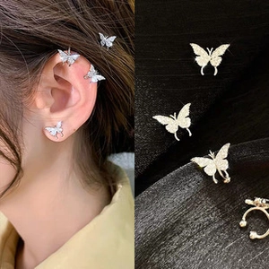 Detailed view of crystal butterfly earrings and ear cuffs set worn on ear and close-up
