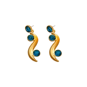 Vintage gold S-shaped wave earrings with blue crystals on a clean white background
