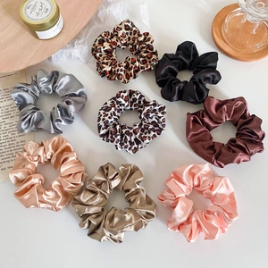 Detailed set of eight satin scrunchies featuring solid colors and leopard patterns