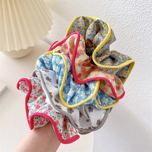 Detail shot of multi-colored floral fabric scrunchies showing texture and edge sewing
