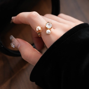 Irregular pearl and zircon open ring in polished gold finish shown on finger