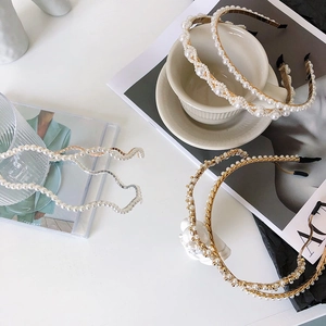 Detailed view of three pearl hairbands with rhinestones and gold bead designs