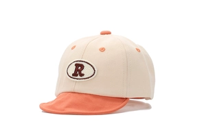 Détail d'une casquette de baseball pour bébé crème et orange avec la lettre R