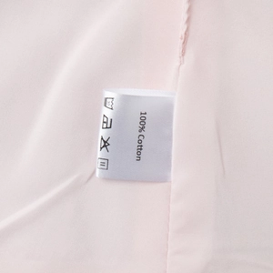 Détail du tissu 100% coton et étiquette d'entretien sur l'ensemble rose clair
