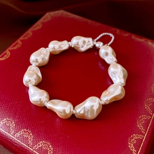 Detailed close-up of Baroque pearl bracelet with silver magnetic clasp on luxury box