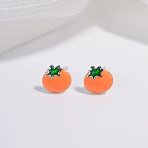 Macro de boucles d'oreilles tomates mignonnes avec finition orange vif et détails de feuilles