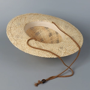 Détails de texture du chapeau de paille tissé main avec cordon à perles et glands