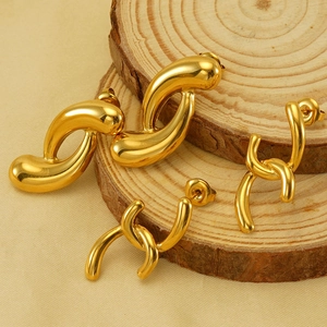 Polished 18k gold plated irregular geometric earrings on natural wood stand