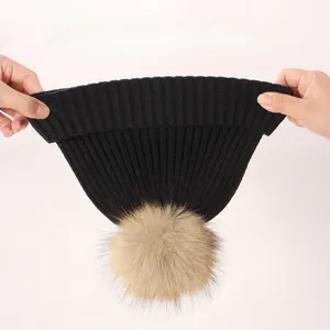 Detail of stretchy ribbed knit beanie with soft faux fur pompom in classic black