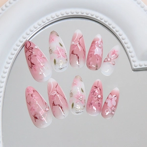 Pink and white gradient almond press-on nails with floral vine patterns and pearl accents