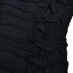 Detailed close-up of ruched black mesh fabric with 3D floral and ruffle embellishments