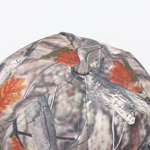 Macro detail of bionic camouflage baseball cap showing stitching and branch leaf patterns