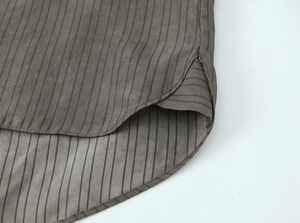 Detailed view of the curved hem and pinstripe pattern on this casual fashion blouse