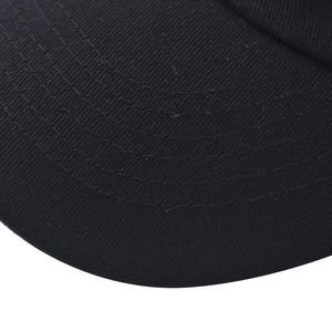Close-up of black cotton baseball cap brim with parallel stitching and twill texture