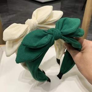 Plush corduroy bunny ear headband with large bow in cream and dark green colors
