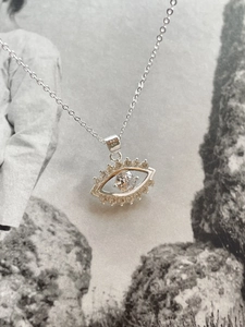 Macro detail of 925 sterling silver evil eye necklace with sparkling cubic zirconia stone