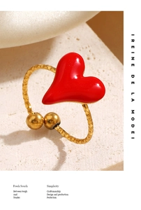 Detailed macro view of the gold heart ring with red oil drip and hammered texture finish