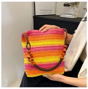Detail of a rainbow woven shoulder bag featuring a unique wooden bead handle and vibrant colors