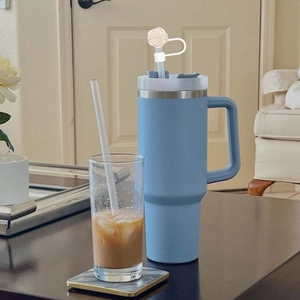Blue insulated tumbler with handle and elegant white rose flower straw cover topper