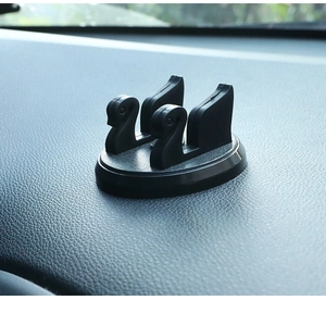 Close-up of black swan-shaped car dashboard phone holder and temporary parking card holder