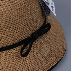 Eleganter brauner Strohhut mit schwarzer Schleife und 99,9 % UV-Schutz-Detail