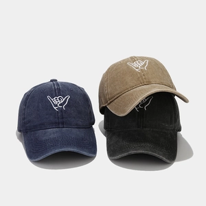 Close-up of Shaka gesture embroidery on washed vintage cotton baseball caps in three colors