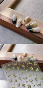 Detail of gold embossed butterfly and leaf nail stickers with actual application effect