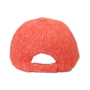 Detail view of coral knitted baseball cap featuring a textured fabric and adjustable back strap