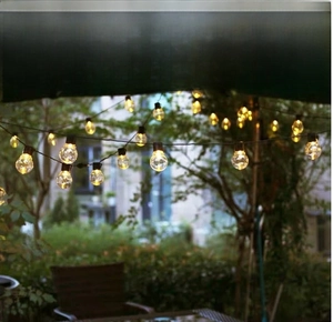 Outdoor waterproof warm white LED string lights hanging under a patio umbrella