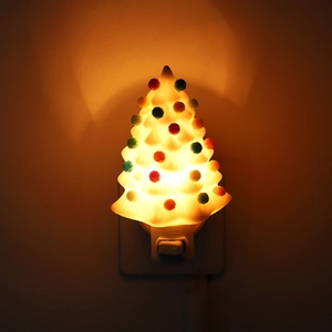 Close-up of white Christmas tree night light with colorful beads and warm glow