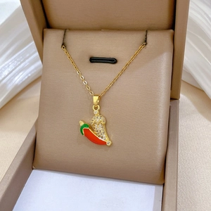 Detail of gold chili pendant necklace featuring crystal paving and red enamel finish