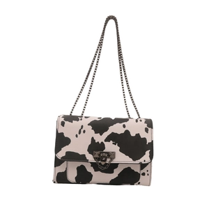 Chic black and white cow print leather shoulder bag with metallic chain strap and lock