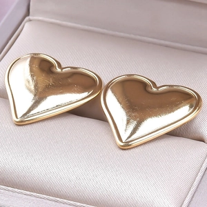 Macro view of gold-plated 304 stainless steel heart earrings in a beige gift box