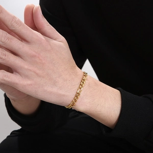 Gros plan d'un bracelet gourmette Figaro doré de 6 mm en acier inoxydable sur un poignet