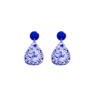 Detailed view of teardrop acrylic earrings with blue and white porcelain floral patterns