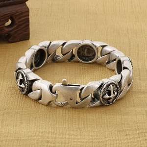 Détail du charme d'ancre en argent vintage sur un bracelet gourmette pour homme