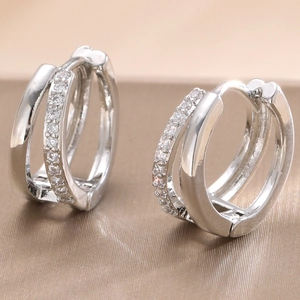 Detailed macro view of silver geometric double-hoop earrings set with clear zircon stones