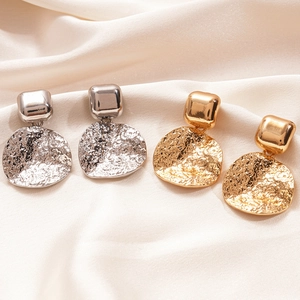 Boucles d'oreilles carrées dorées et argentées avec disques martelés sur du satin