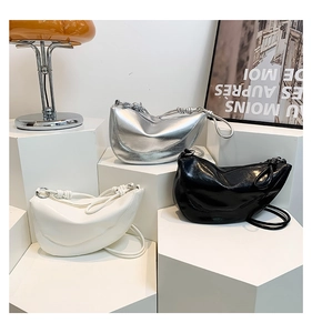 Three half-moon saddle bags in silver, black and white on modern geometric stands