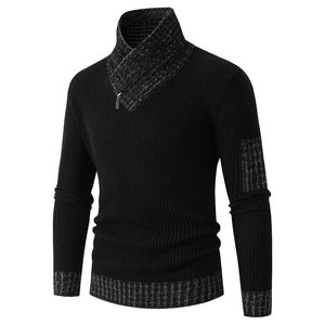 Dettaglio del maglione in maglia nero con polsini grigi e cerniera in metallo decorativa